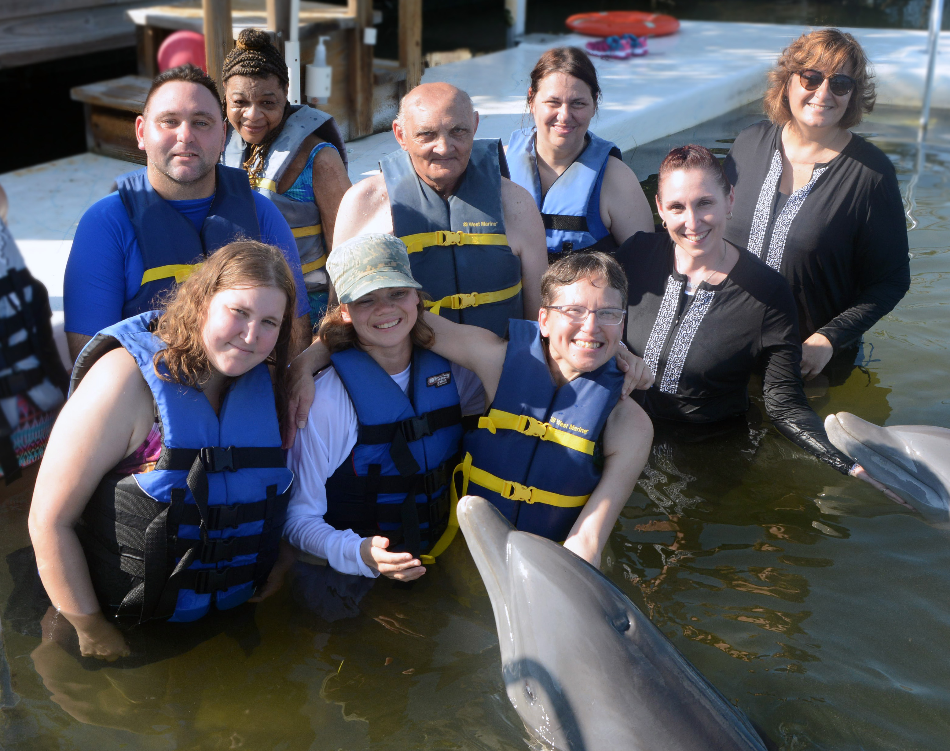 Vacationers and escorts with a friendly dolphin.