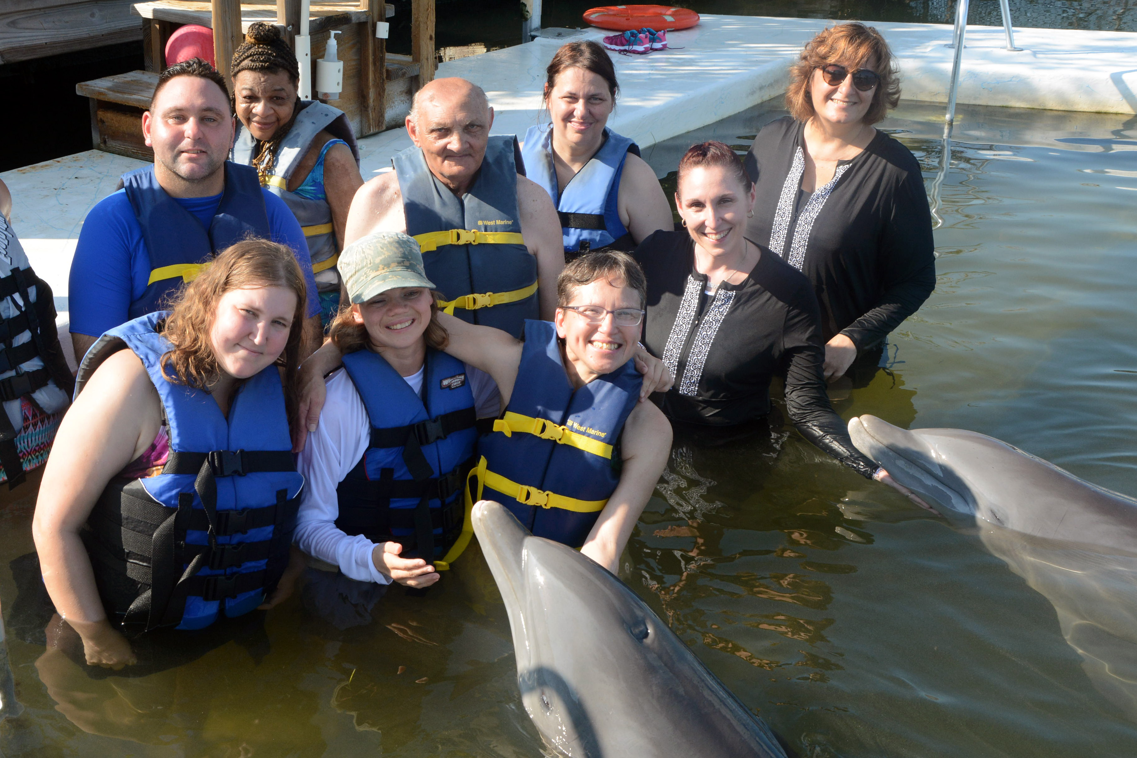 Vacationers and escorts with a friendly dolphin.